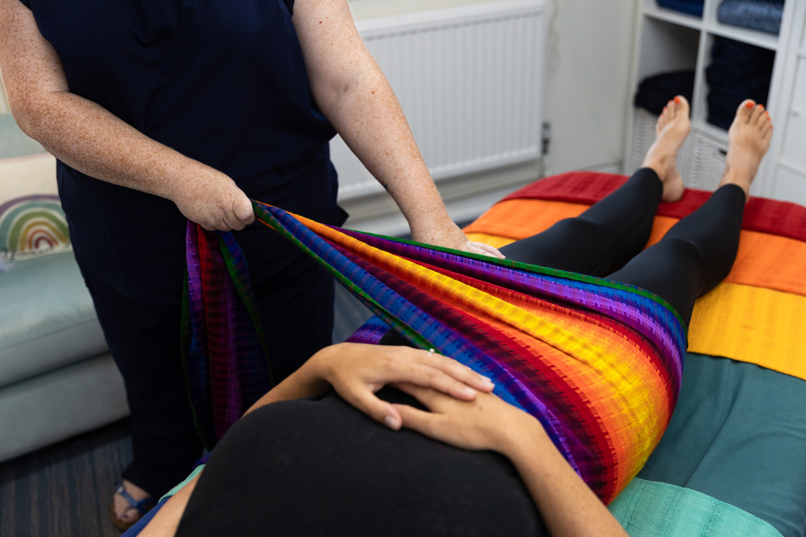 Julia Walder of Willow Grace Perinatal and Holistic Therapies completing a closing the bones postnatal massage on a mum using rebozos at Rumwell Hall Near Taunton Somerset